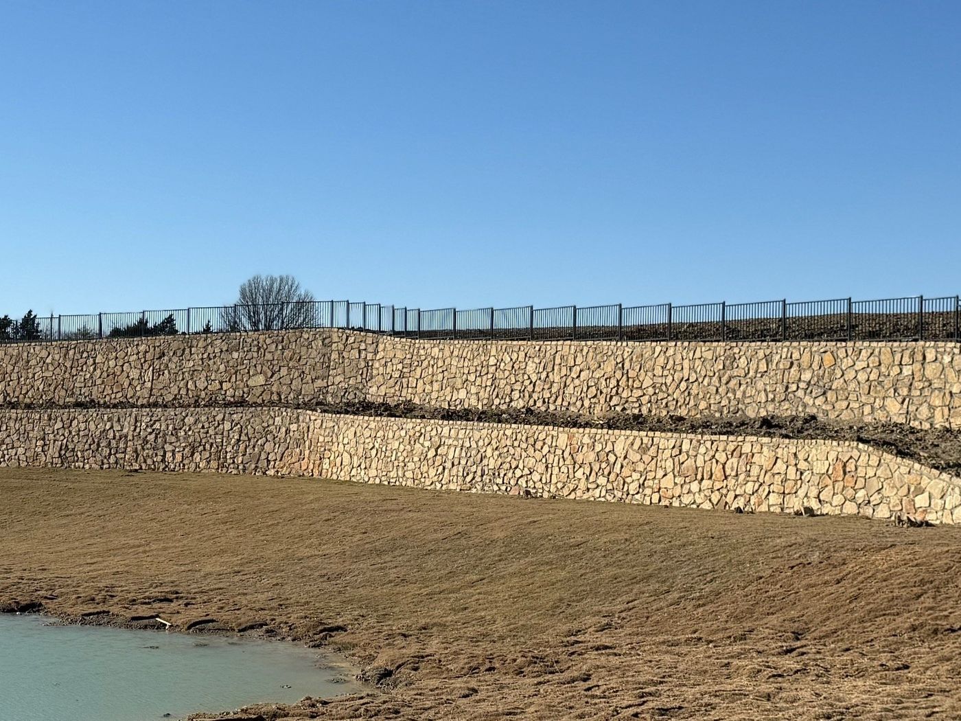 Tiered stone retaining walls around a pond in Princeton
