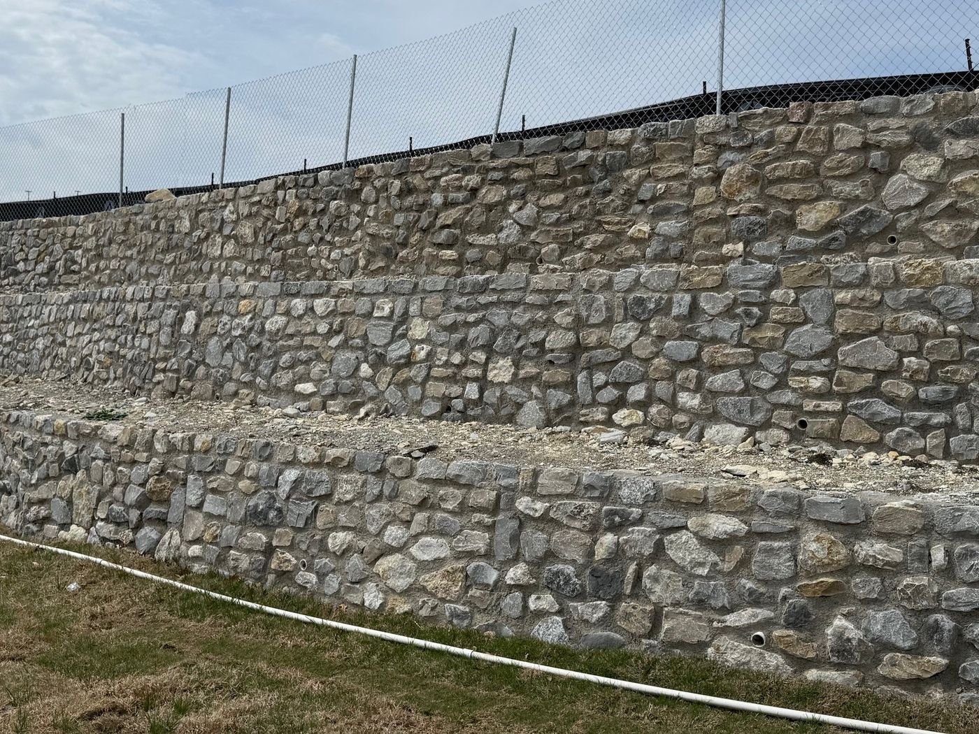Tiered stone walls with a fence on top, Oxenfree at Stonebriar, Frisco
