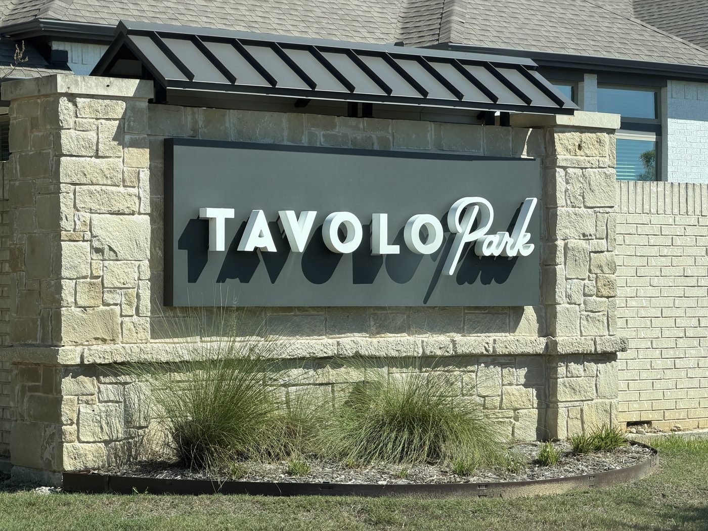 Stone entry monument with a standing seam metal roof, Tavolo Park, Fort Worth