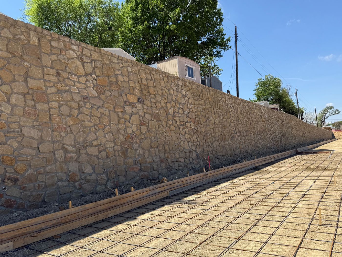 Tall stone retaining wall before paving, Valley View Industrial, Irving