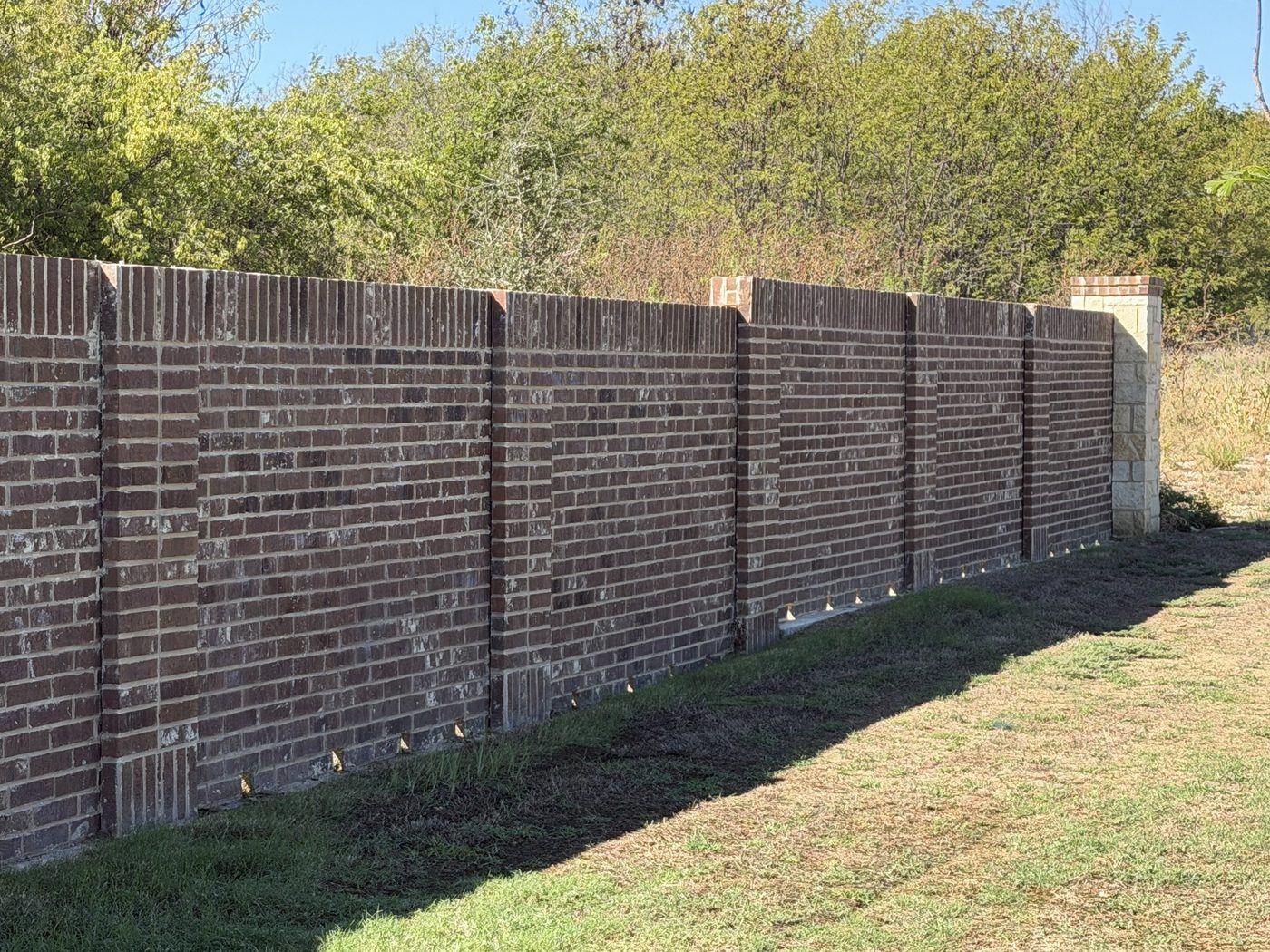 Brick screen wall with brick columns and a stone end column, Westpoint Park, Fort Worth